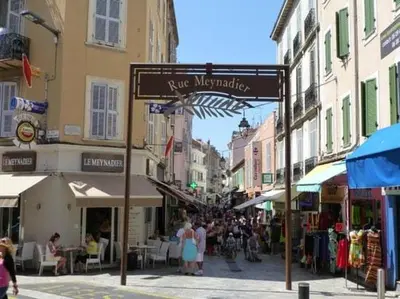 a street sign in a city with people walking down a street at Sublime apartment 100 m from the Croisette in Cannes