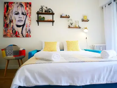 a bedroom with a white bed and a painting on the wall at Sublime apartment 100 m from the Croisette in Cannes