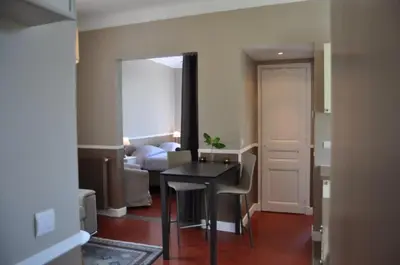 a living room with a table and a bedroom at Maison palm in Cannes