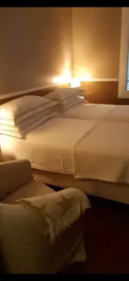 two white beds in a room with a window at Maison palm in Cannes