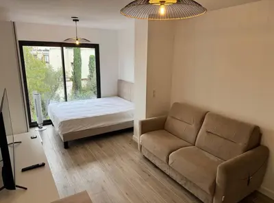 a living room with a couch and a bed at Studios Cannes Les 3 éléments in Cannes