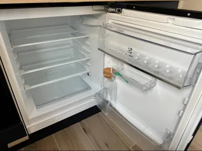 an empty refrigerator with its door open and a bottle in it at Studios Cannes Les 3 éléments in Cannes