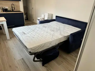 a bed in a room with a blue bed frame at Studios Cannes Les 3 éléments in Cannes