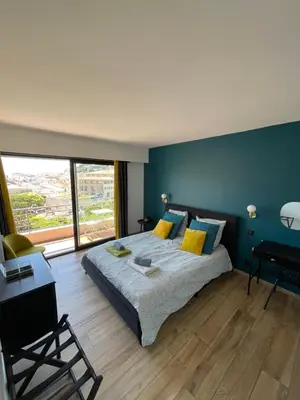 a bedroom with a large bed and a large window at 2 pièces vue sur le Suquet in Cannes