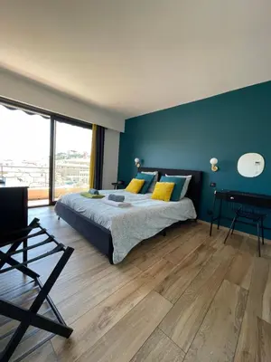 a bedroom with a bed and a blue wall at 2 pièces vue sur le Suquet in Cannes