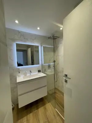 a bathroom with a sink and a shower and a mirror at 2 pièces vue sur le Suquet in Cannes