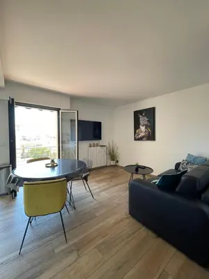 a living room with a couch and a table at 2 pièces vue sur le Suquet in Cannes