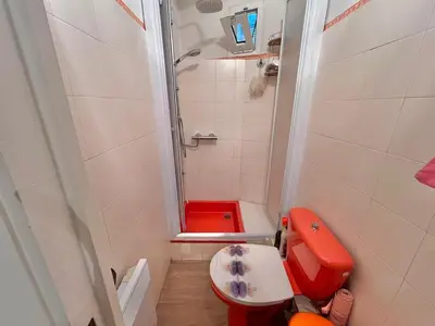 a small bathroom with a red toilet and a shower at 3 Pièces à 100m de la Croisette in Cannes