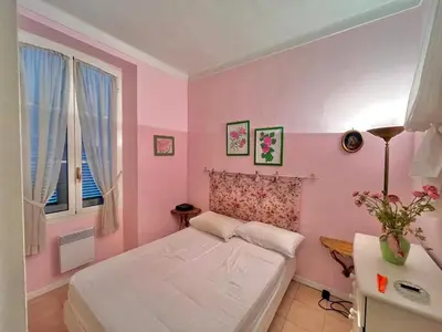 a pink bedroom with a bed and a desk at 3 Pièces à 100m de la Croisette in Cannes
