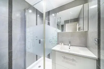 a white bathroom with a shower and a sink at Rooftop La Croisette Cannes in Cannes