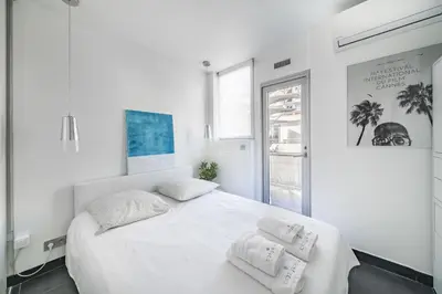 a white bedroom with a large bed with two pillows at Rooftop La Croisette Cannes in Cannes