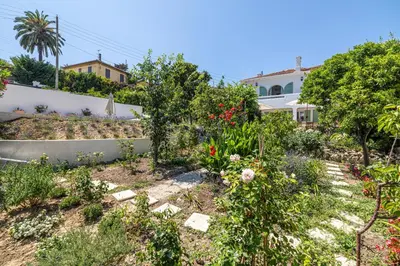 a garden in front of a house at LA VILLA DES FLEURS en duplex avec jardin et piscine in Le Cannet
