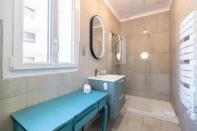 a bathroom with a blue bench and a sink at LA VILLA DES FLEURS en duplex avec jardin et piscine in Le Cannet