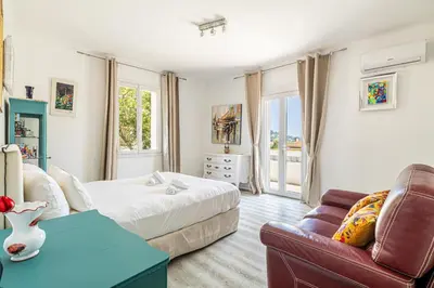 a bedroom with a bed and a couch at LA VILLA DES FLEURS en duplex avec jardin et piscine in Le Cannet