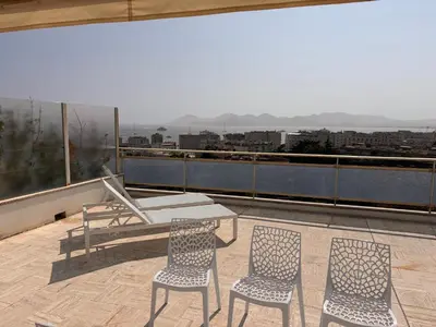 a patio with a table and chairs on a roof at Appart exceptionnel terrasse mer in Cannes