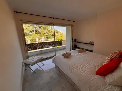 a bedroom with a bed and a large window at Appart exceptionnel terrasse mer in Cannes