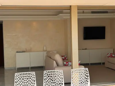 a living room with a couch and a television on a wall at Appart exceptionnel terrasse mer in Cannes