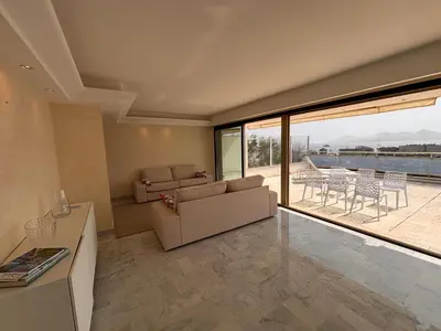 a living room with a couch and a table and chairs at Appart exceptionnel terrasse mer in Cannes