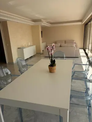 a white table with a vase of flowers on it at Appart exceptionnel terrasse mer in Cannes