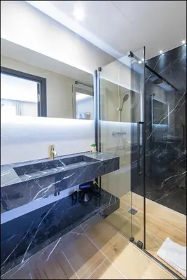 a bathroom with a sink and a glass shower at Hôtel particulier Marceau - Centre - Neuf - Suites de 3 à 28 chambres in Cannes