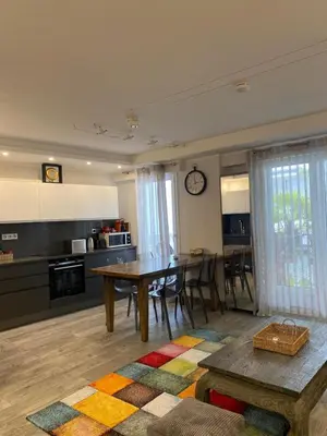 a living room with a table and a kitchen at Pretty flat in Cannes