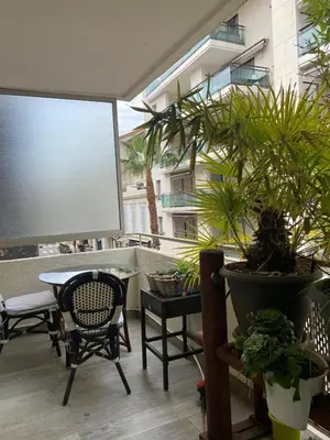 a patio with a table and chairs and potted plants at Pretty flat in Cannes