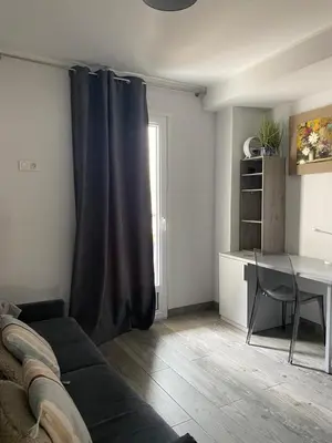 a living room with a table and a black curtain at Pretty flat in Cannes