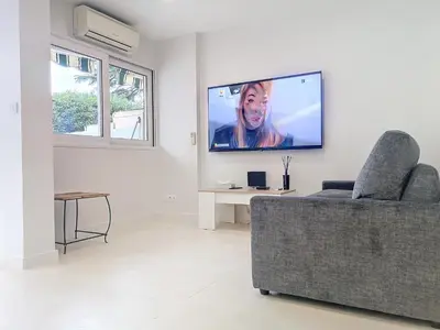 a living room with a couch and a flat screen tv at Appartement terrasse Cannes Suquet proche plage et centre in Cannes