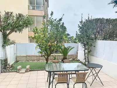 a patio with a table and chairs and trees at Appartement terrasse Cannes Suquet proche plage et centre in Cannes