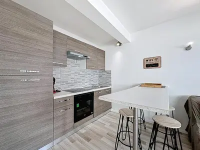 a kitchen with a table and stools in a room at Rivieira - By Coco in Cannes