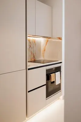 a kitchen with white cabinets and a stove top oven at 2 Appartements porte à porte Groupe & famille in Cannes