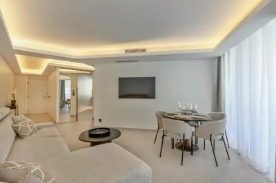 a living room with a couch and a table at 2 Appartements porte à porte Groupe & famille in Cannes