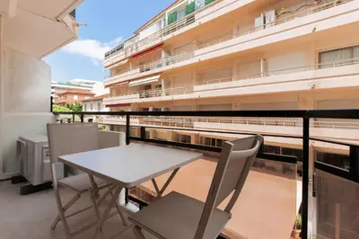 a balcony with a table and chairs and a building at 2 Appartements porte à porte Groupe & famille in Cannes