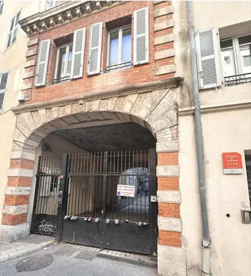an entrance to a building with a black gate at Elegant old port apartment in Cannes