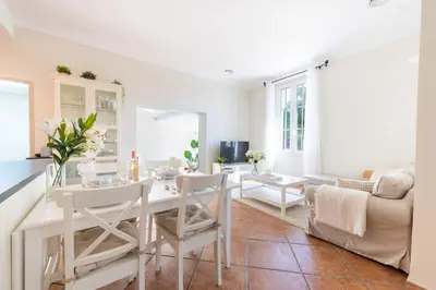 a white living room with a table and chairs at 140m Villa with Pool Near Cannes in Le Cannet