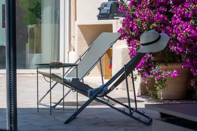 a chair with a hat sitting next to a table at 140m Villa with Pool Near Cannes in Le Cannet