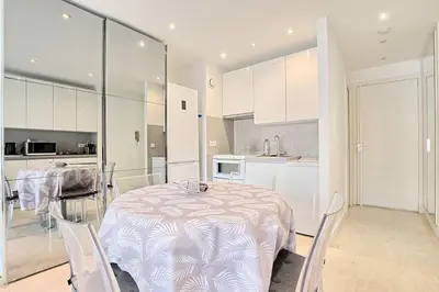 a kitchen and dining room with a table and chairs at Studio lumineux avec parking - Gare & Palais à pied in Cannes