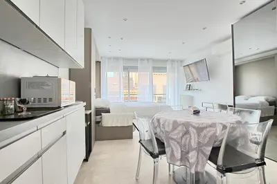 a kitchen and dining room with a table and chairs at Studio lumineux avec parking - Gare & Palais à pied in Cannes
