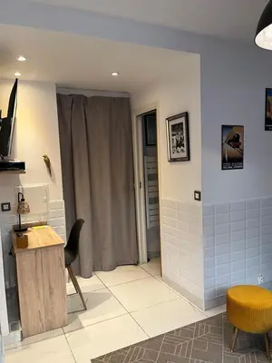 a living room with a table and a chair at Studio à 100 mètres de la plage et de la Croisette in Cannes