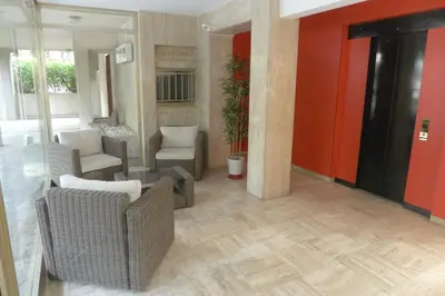 a lobby with chairs and tables and a red wall at Studio à 100 mètres de la plage et de la Croisette in Cannes