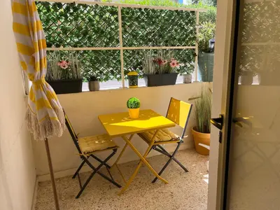 a yellow table and chairs in front of a window at Studio à 100 mètres de la plage et de la Croisette in Cannes