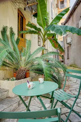 a green table and chairs on a patio with plants at Sandra - Atypical and Charming - Suquet - VCA in Cannes