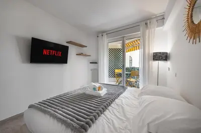a white bedroom with a bed with amet sqor at Reine Astrid Palm Beach Suite in Cannes