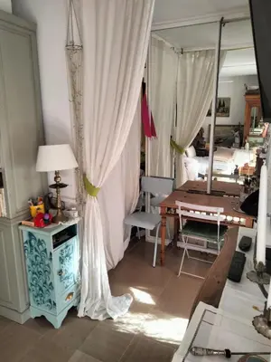 a living room with a table and a curtain at Near Croisette atypic studio garden pool in Cannes