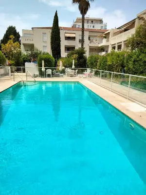 a large blue swimming pool in front of a building at Near Croisette atypic studio garden pool in Cannes