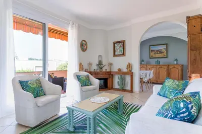 a living room with a couch and chairs and a table at Villa Les Chênes Verts by Halldis in Le Cannet