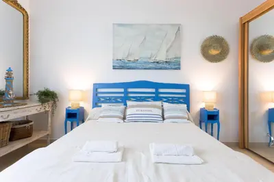 a blue bedroom with a bed with two white pillows at Villa Les Chênes Verts by Halldis in Le Cannet