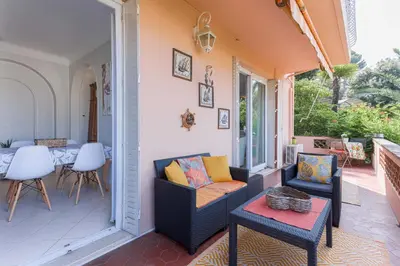 a porch with two chairs and a table at Villa Les Chênes Verts by Halldis in Le Cannet