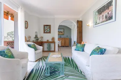 a living room with two white couches and a table at Villa Les Chênes Verts by Halldis in Le Cannet