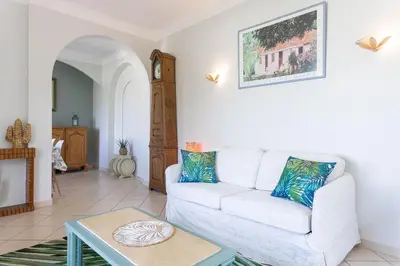 a living room with a white couch and a table at Villa Les Chênes Verts by Halldis in Le Cannet